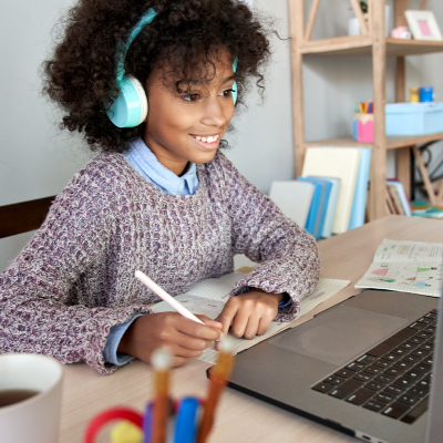 Teen girl with headphones looking at her computer