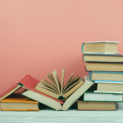 Stack of books in front of a pink background