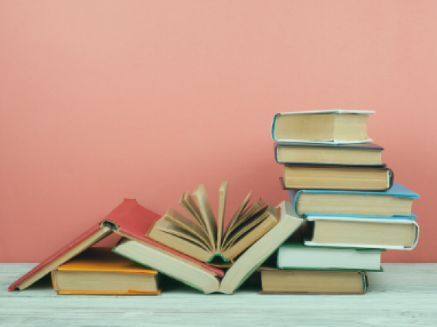 An image of a stack of books. Several are open.